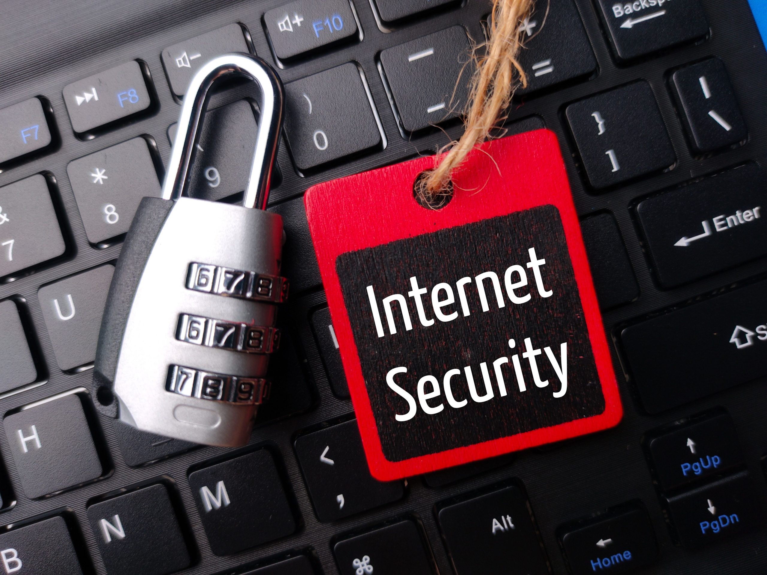 Top view of padlock and wooden board with the word Internet Security on a wireless keyboard